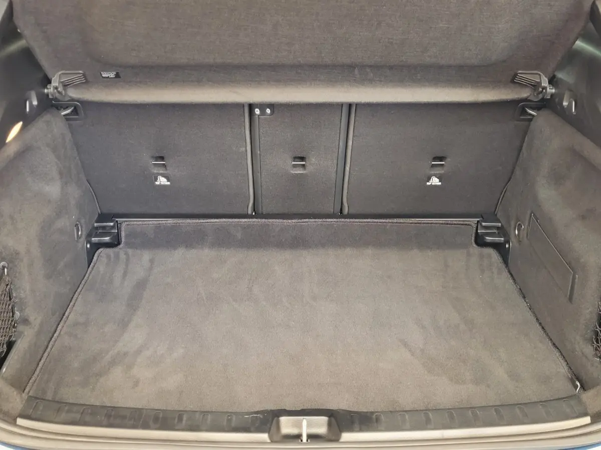 Coffre ouvert du Mercedes GLA 200 D bleu 2022, montrant l'espace de chargement avec banquette arrière rabattable.