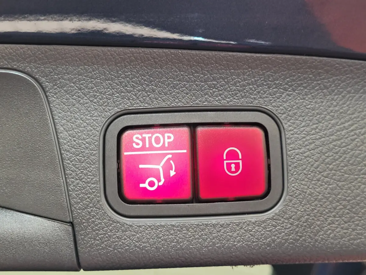 Gros plan sur les boutons rouges de fermeture et arrêt du hayon du Mercedes GLA 200 D bleu, version 2022.