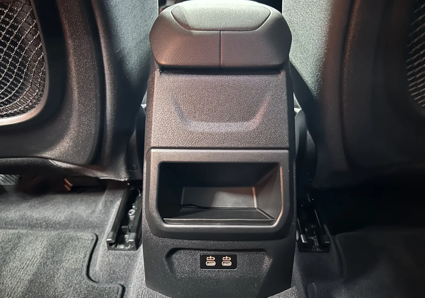 Vue rapprochée de la console centrale arrière noire de la BMW Série 1 116d 2023 avec ports USB visibles au bas.