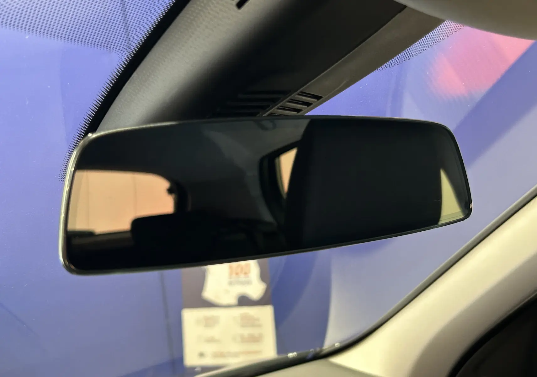 Rétroviseur intérieur de BMW Série 1 116d 2023, vue rapprochée avec reflet sombre et cadre noir.