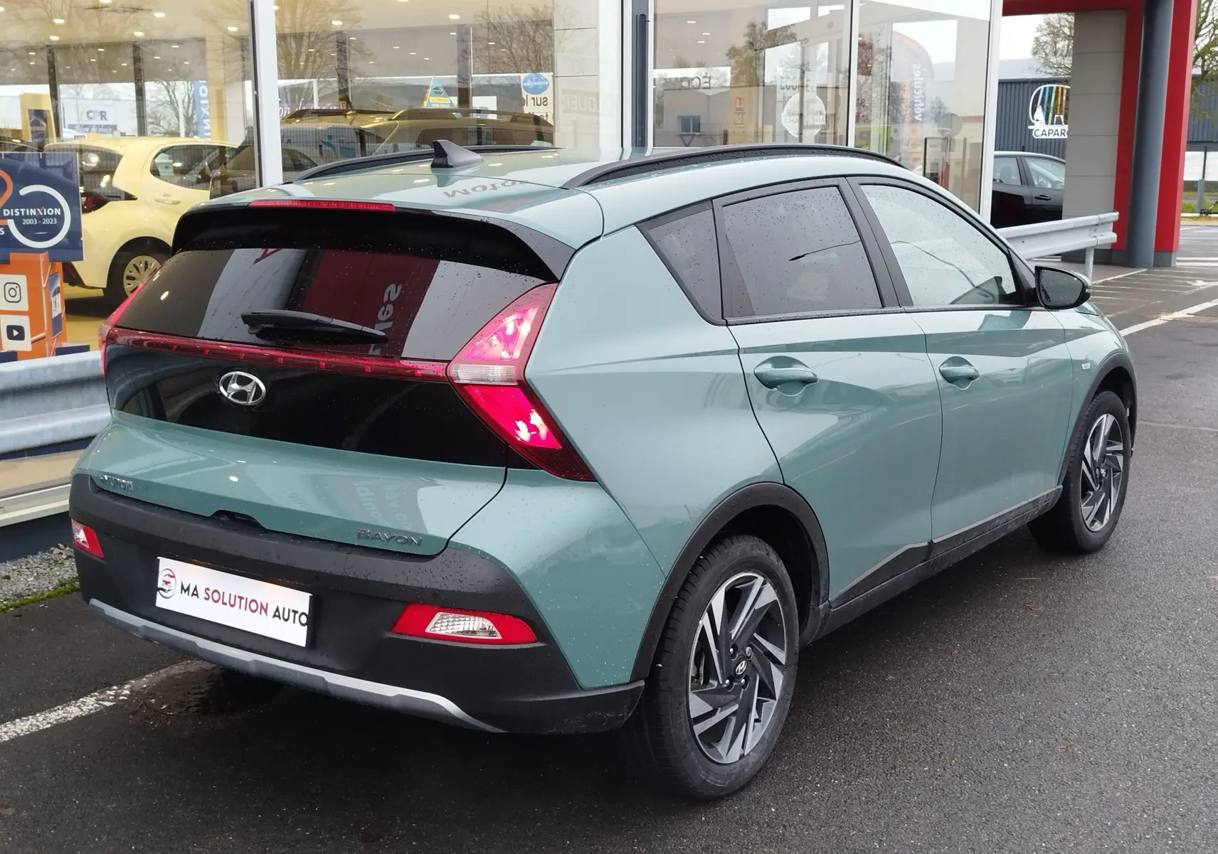 Vue 3/4 arrière droite d’un Hyundai Bayon 2022 vert Elemental Brass Metal avec feux arrière LED et jantes alliage.