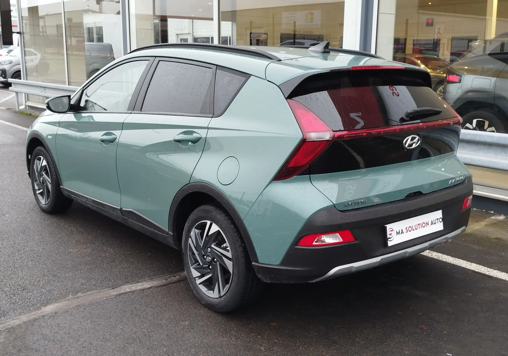 Vue 3/4 arrière droite d’une Hyundai Bayon 2022 hybride en couleur Elemental Brass Metal avec feux arrière distinctifs en forme de T.