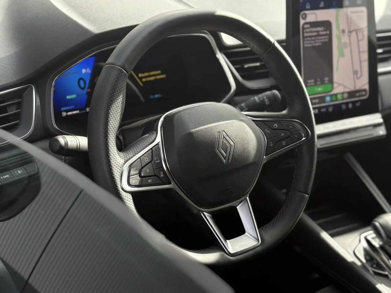 Gros plan sur le volant en cuir noir et le tableau de bord numérique du Renault SYMBIOZ E-Tech Full Hybrid 2025.