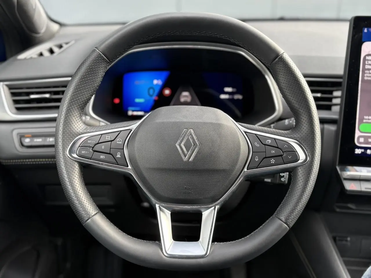 Vue rapprochée du volant noir en cuir perforé avec commandes intégrées du Renault Symbioz E-Tech Full Hybrid 2025.