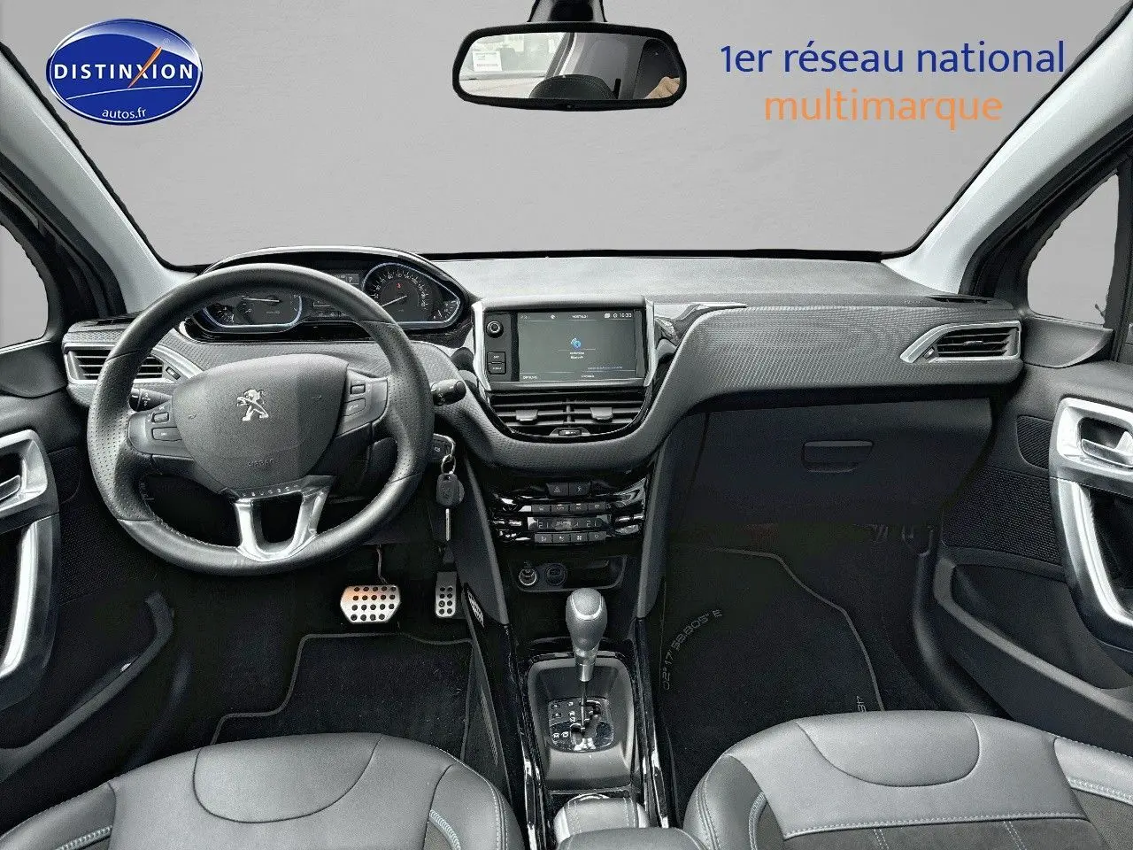 Vue intérieure avant de la Peugeot 2008 gris platinium de 2019, avec tableau de bord moderne et volant cuir multifonction.