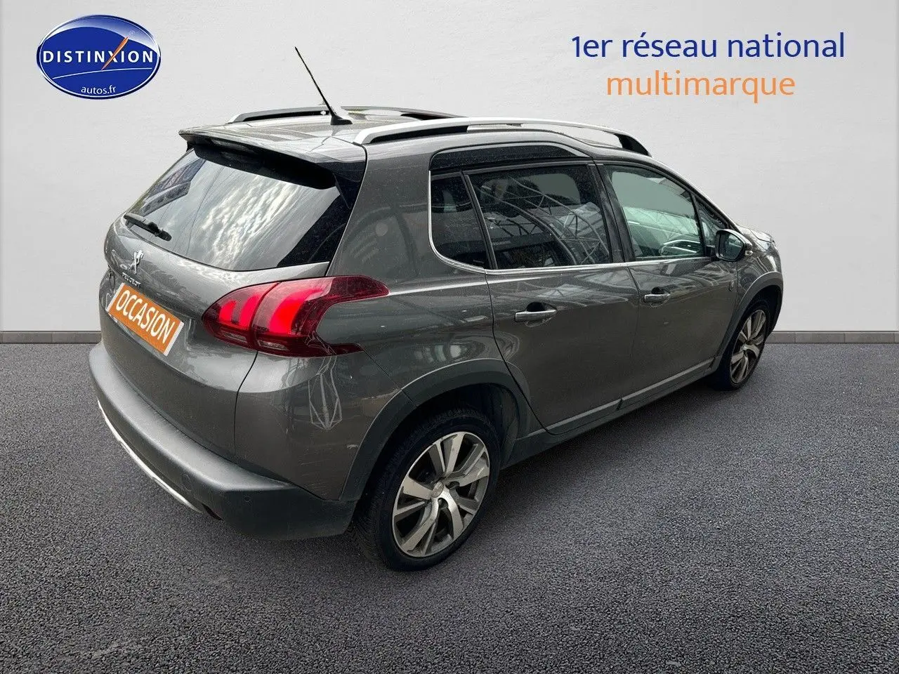 Vue 3/4 arrière droite du Peugeot 2008 gris platinium avec barres de toit et jantes alliage 17 pouces.