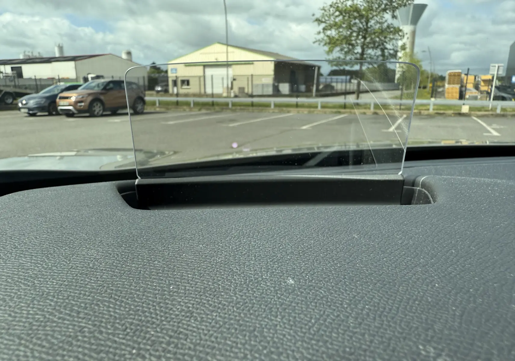 Affichage tête haute transparent sur le tableau de bord gris texturé d'une DS3 2024 gris laqué toit noir, vue intérieure frontale.