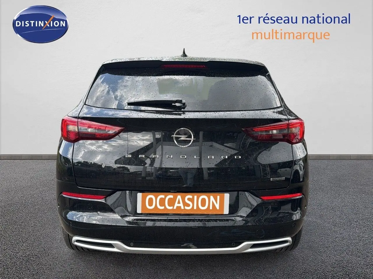 Vue arrière d'un Opel Grandland noir 2024 hybride rechargeable avec feux LED et logo central bien visibles.