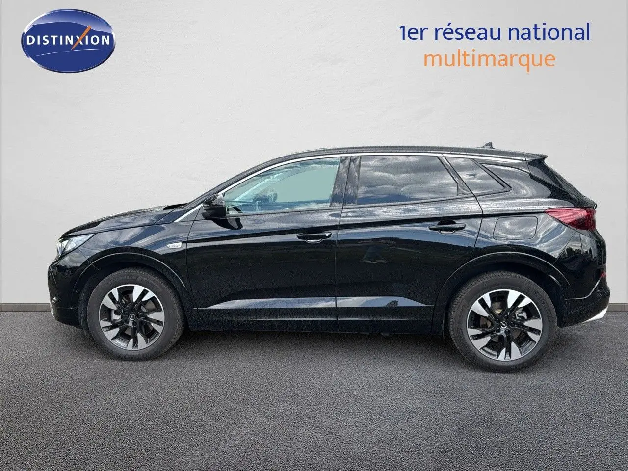 Profil côté gauche d'un Opel Grandland noir 2024 hybride rechargeable avec jantes bi-ton et lignes épurées.