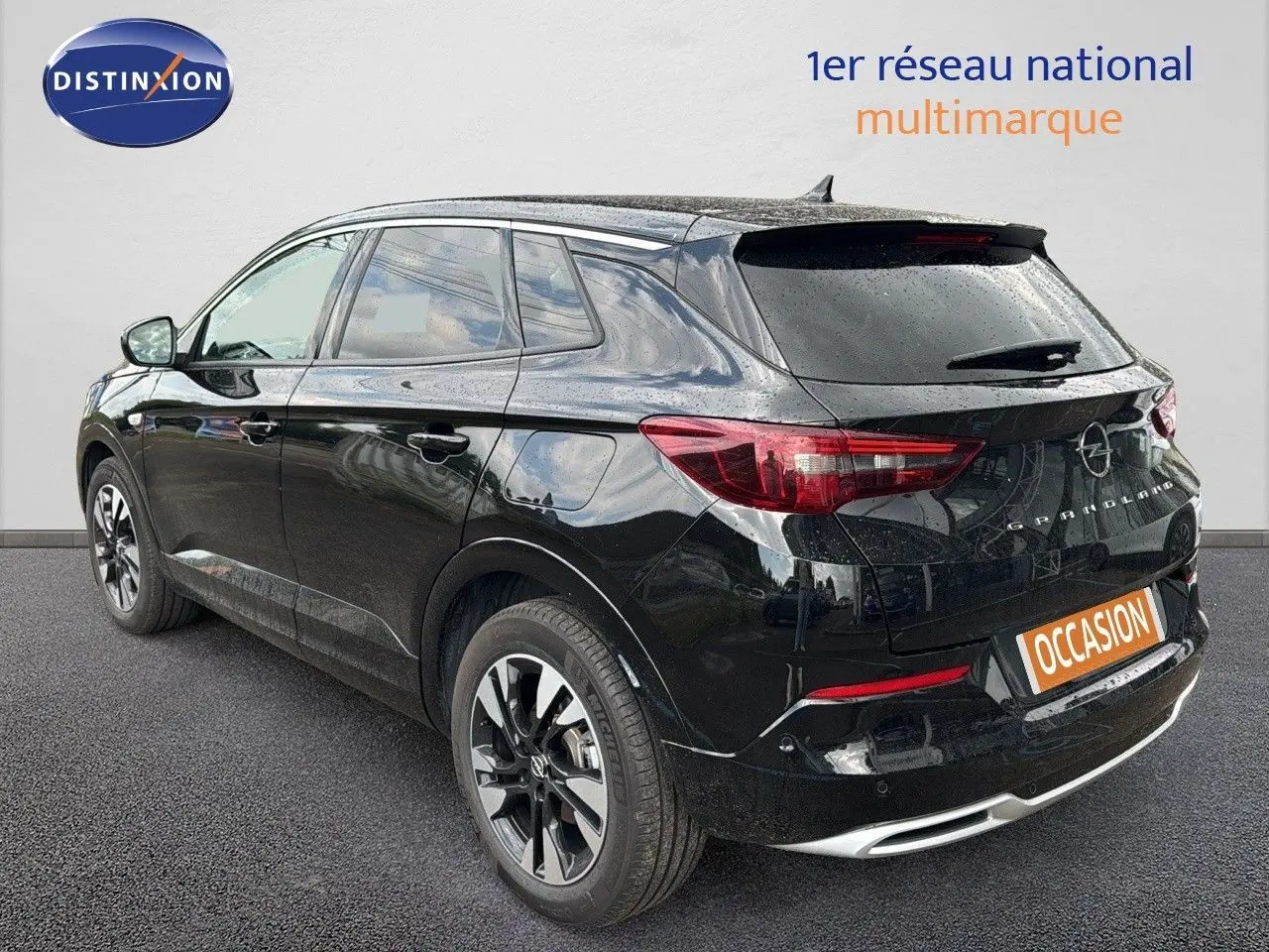 Opel Grandland hybride rechargeable noir vu en 3/4 arrière droit avec jantes biton et feux arrière LED.