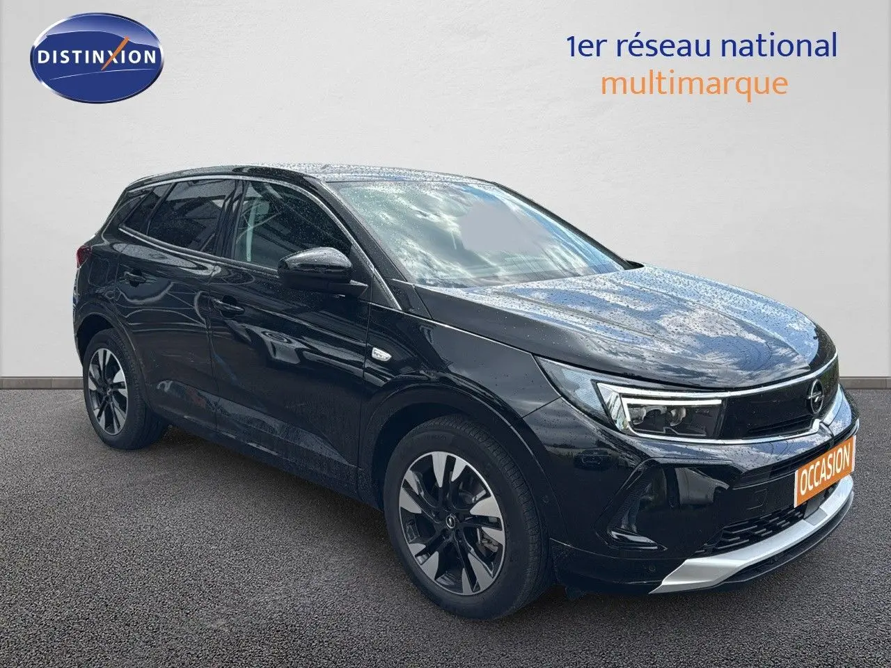 Opel Grandland 1.6 Turbo hybride noir en 3/4 avant droit avec jantes biton et calandre chromée visible