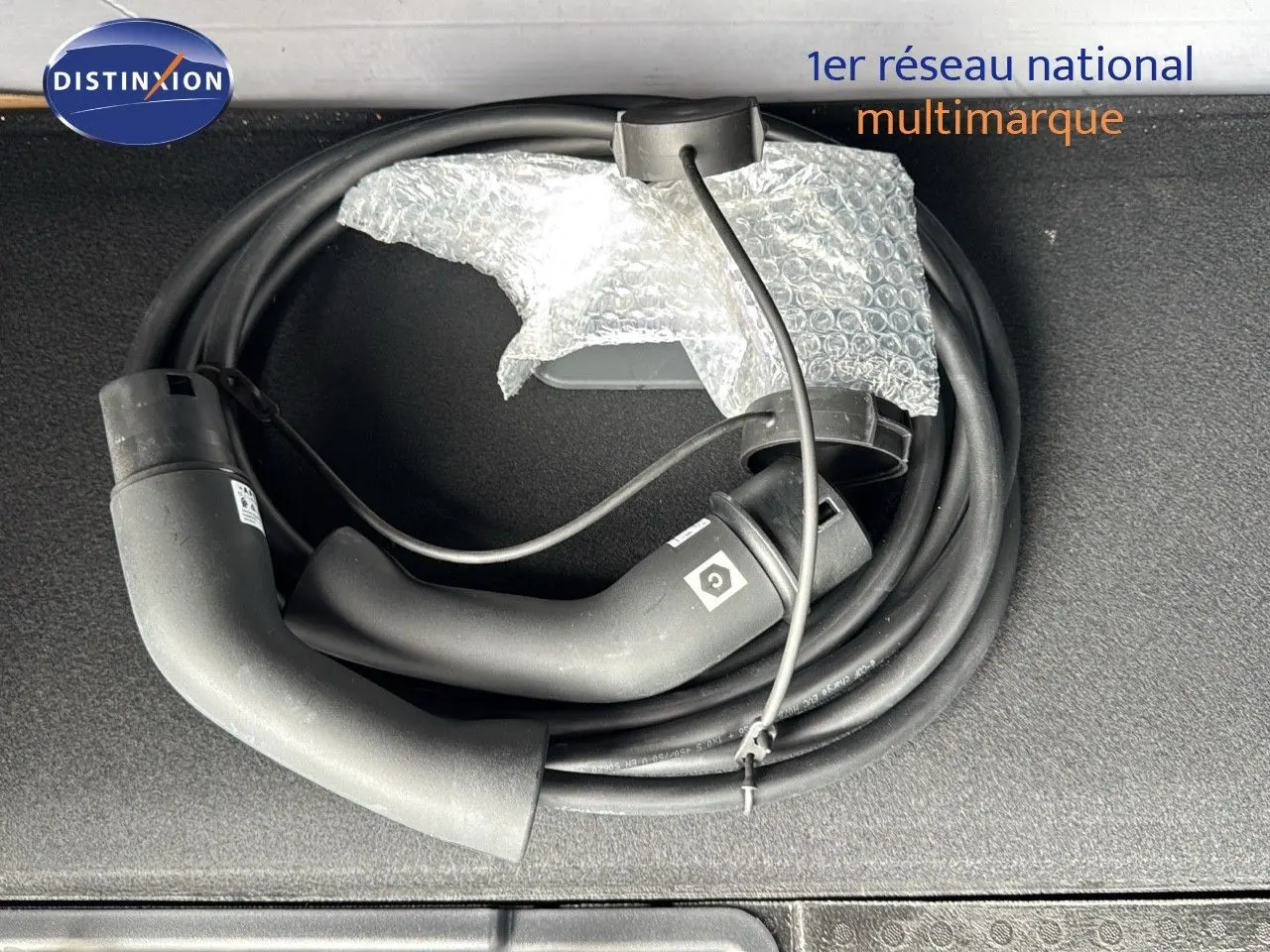 Câble de recharge noir enroulé dans le coffre d'un Opel Grandland hybride rechargeable 2024.