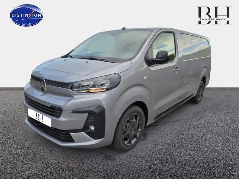 Vue 3/4 avant droit d'un Citroën Jumpy Fourgon XL gris acier métal avec phares allumés et jantes noires.