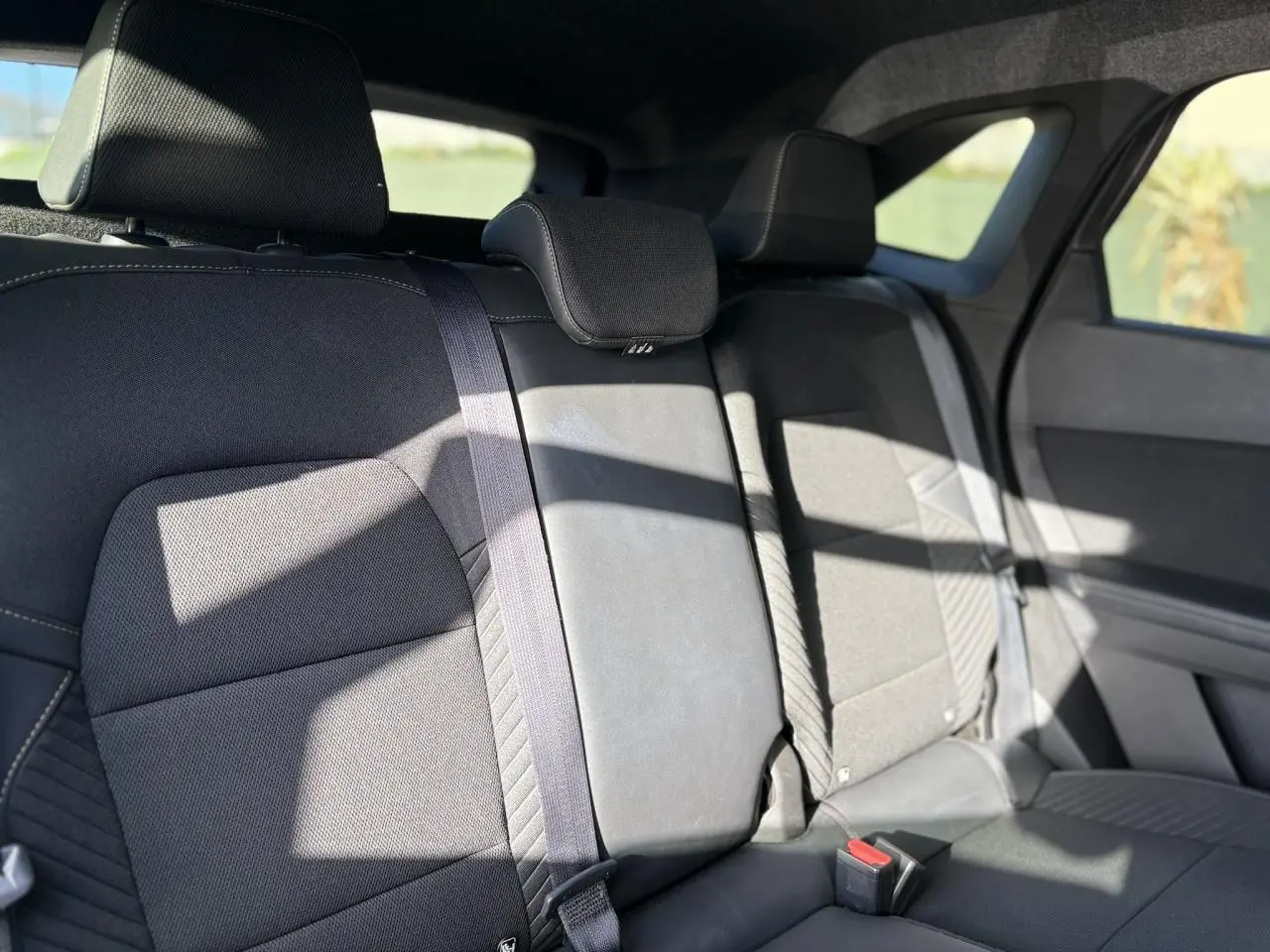 Vue intérieure des sièges arrière noirs du Renault SYMBIOZ E-Tech Full Hybrid 2025 avec appuie-têtes et ceintures visibles.