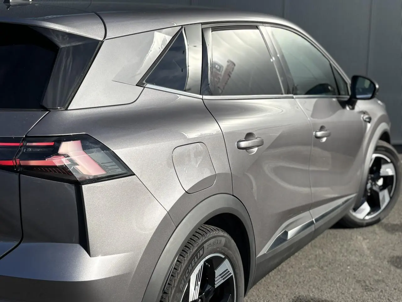 Vue 3/4 arrière côté droit du Renault SYMBIOZ gris Cassiopée avec jantes 18 pouces et hayon mains libres.