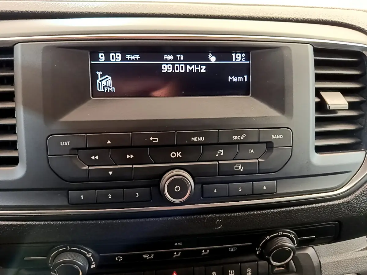 Vue rapprochée du tableau de bord noir du Toyota Proace Verso 2019 avec écran radio affichant 99.00 MHz.