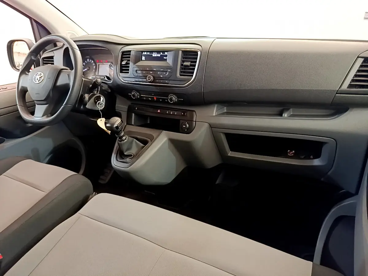 Intérieur du Toyota Proace Verso 2019 en vue avant droite, montrant tableau de bord noir et sièges gris clair.
