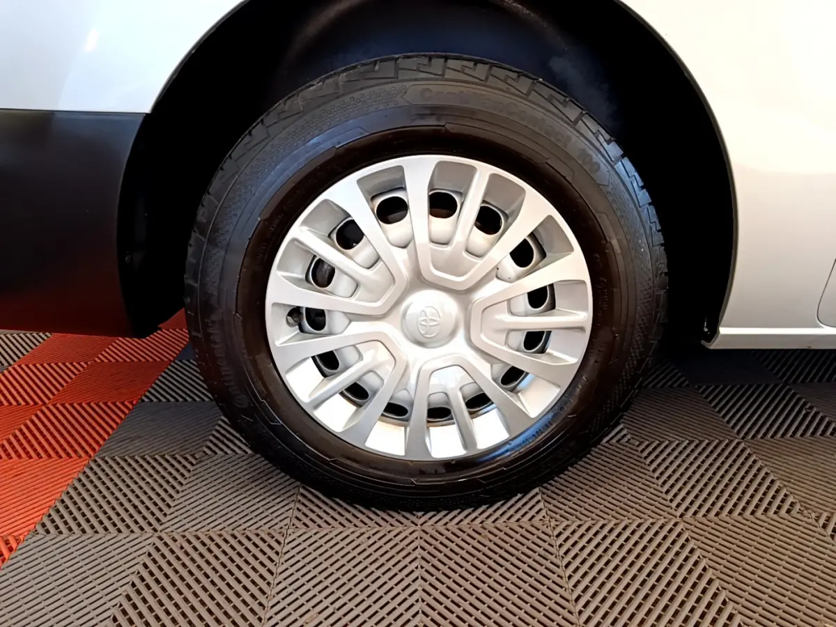 Gros plan sur la roue avant droite d'un Toyota Proace Verso gris clair de 2019 avec enjoliveur argenté et logo Toyota.