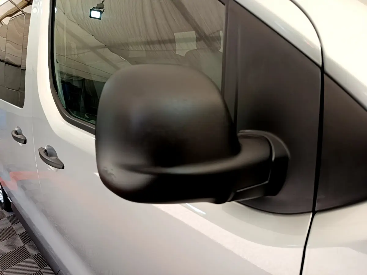 Rétroviseur noir en gros plan côté gauche d'un Toyota Proace Verso gris clair 2019, vue latérale partielle.