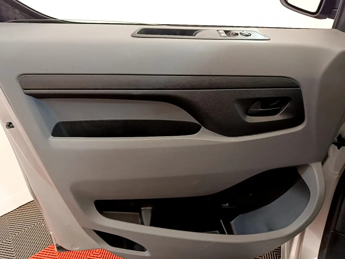 Panneau de porte côté gauche gris clair du Toyota Proace Verso 2019 avec poignée et commandes électriques.
