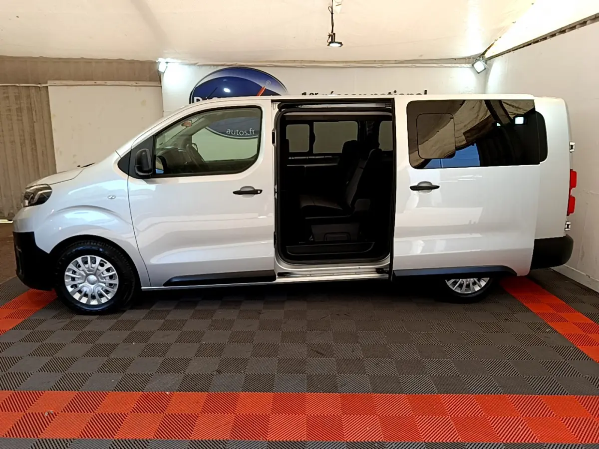 Profil droit du Toyota Proace Verso gris clair 2019 avec porte latérale coulissante ouverte montrant l'intérieur.