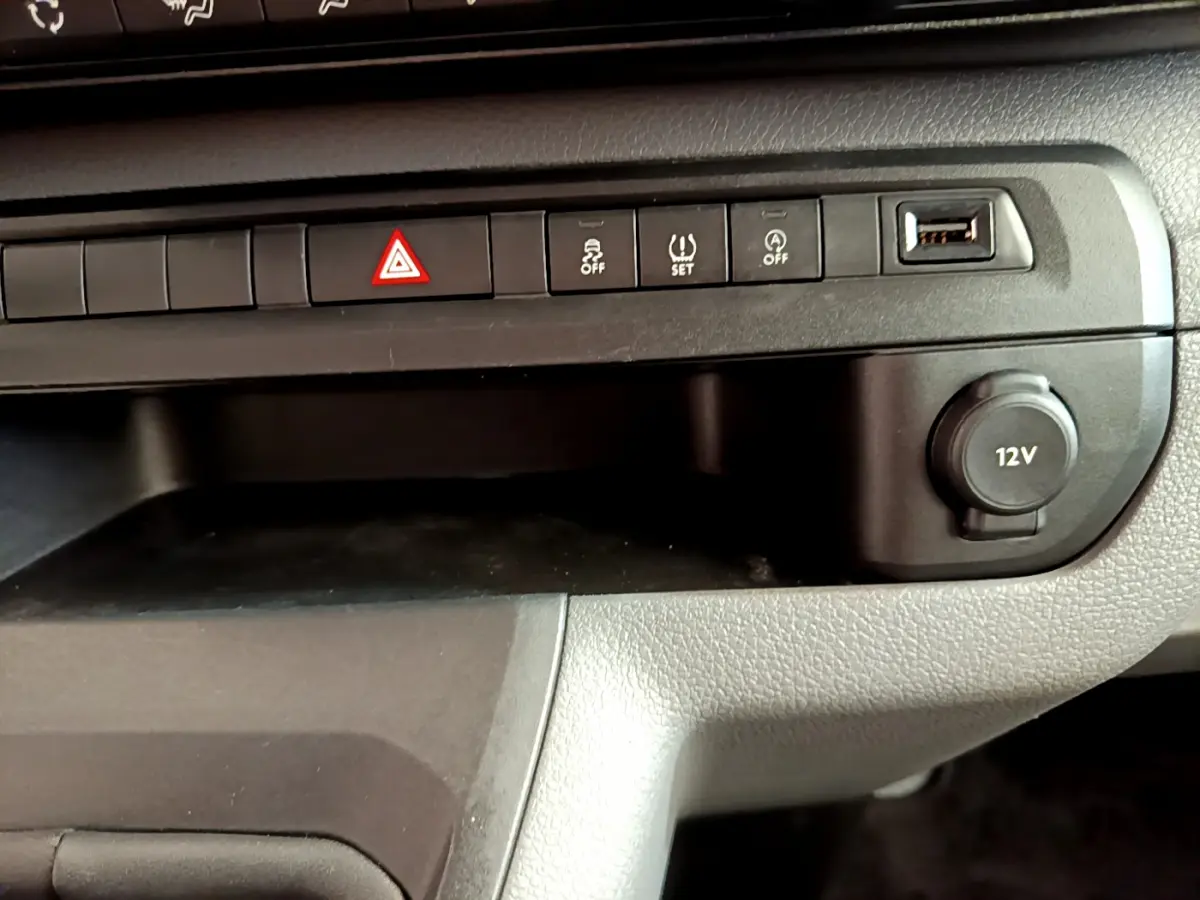 Gros plan sur la console centrale noire du Toyota Proace Verso 2019 avec boutons de sécurité et prise 12V visible