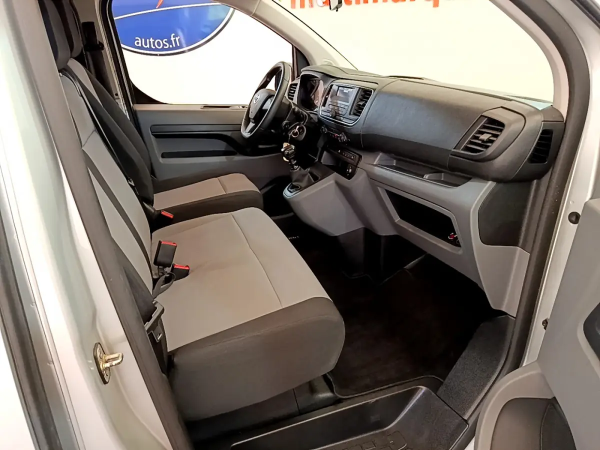 Intérieur avant droit du Toyota Proace Verso gris clair 2019 avec sièges bicolores et tableau de bord fonctionnel.
