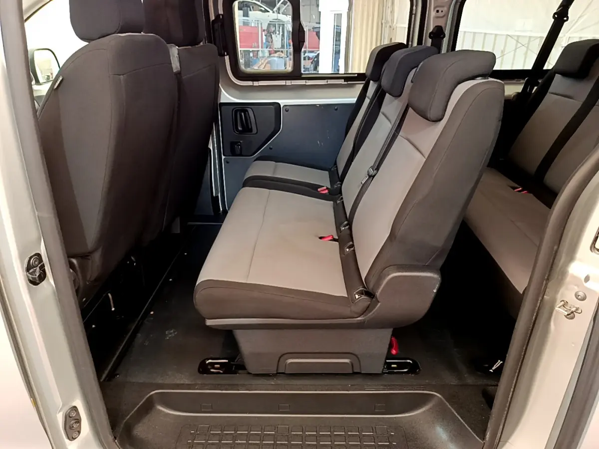 Vue intérieure côté droit du Toyota Proace Verso 2019, sièges gris clair et foncé en tissu, espace passagers visible.