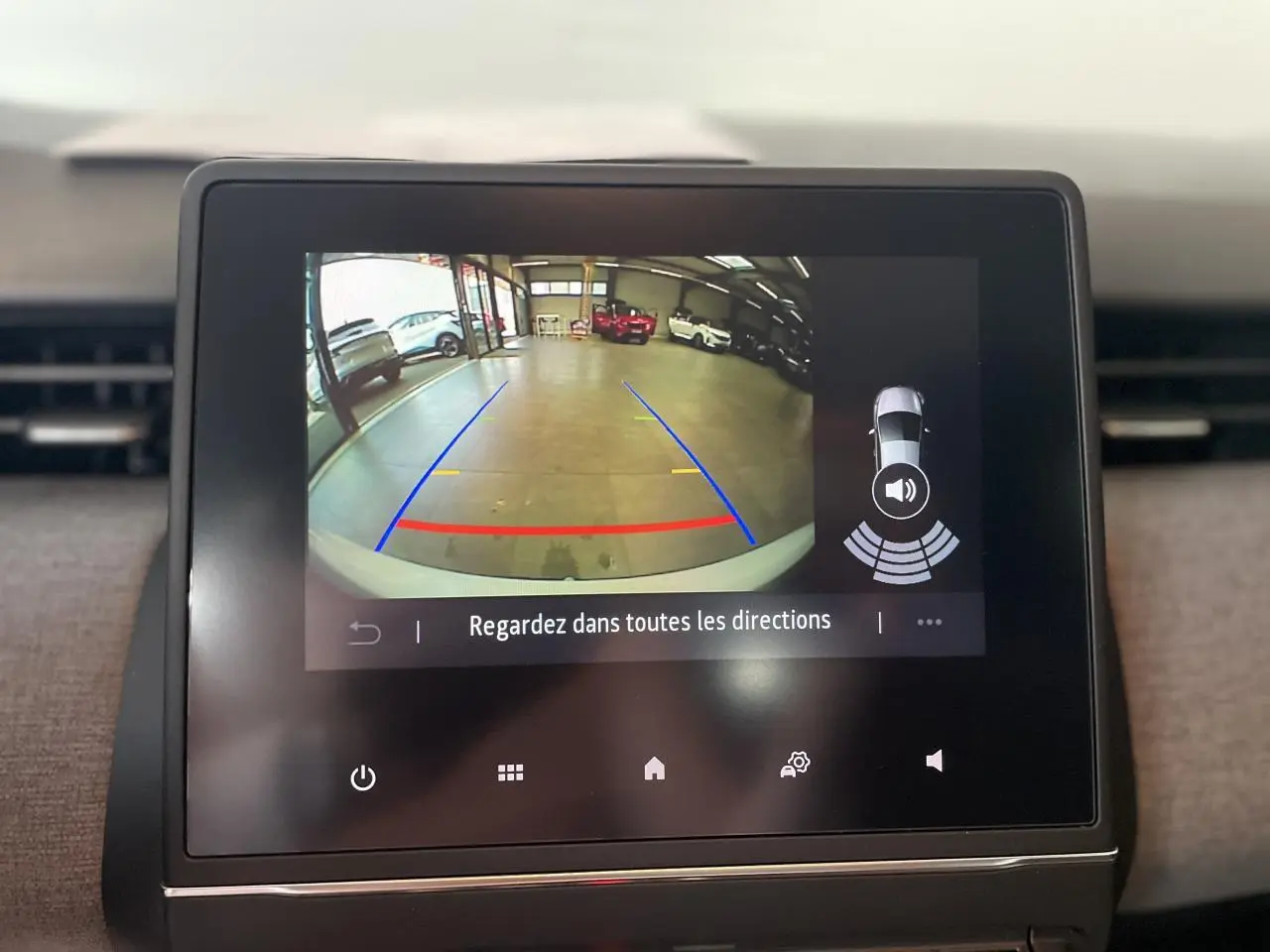 Écran tactile intérieur montrant la caméra de recul avec lignes de guidage sur Renault Clio blanche 2025.