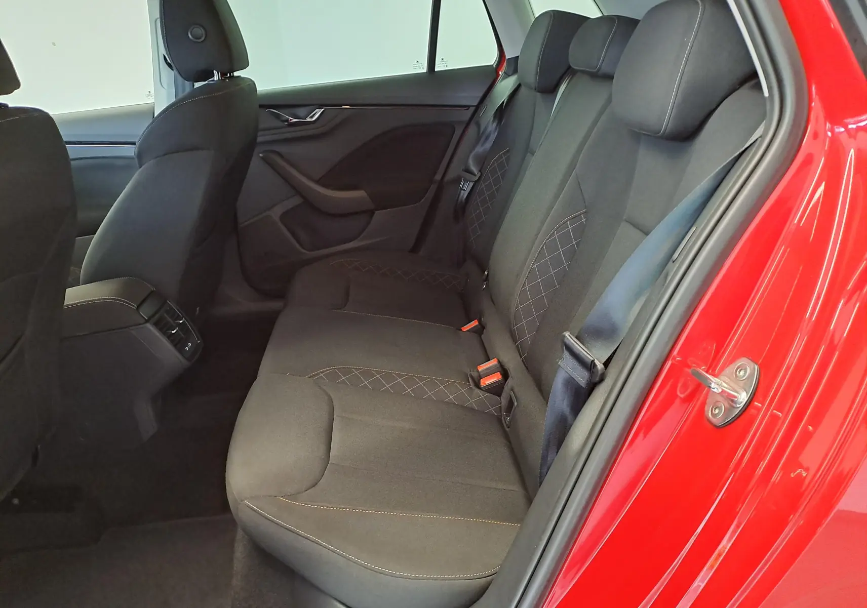 Vue intérieure côté droit des sièges arrière noirs avec surpiqûres contrastantes du Skoda Kamiq Rouge Velvet 2024.