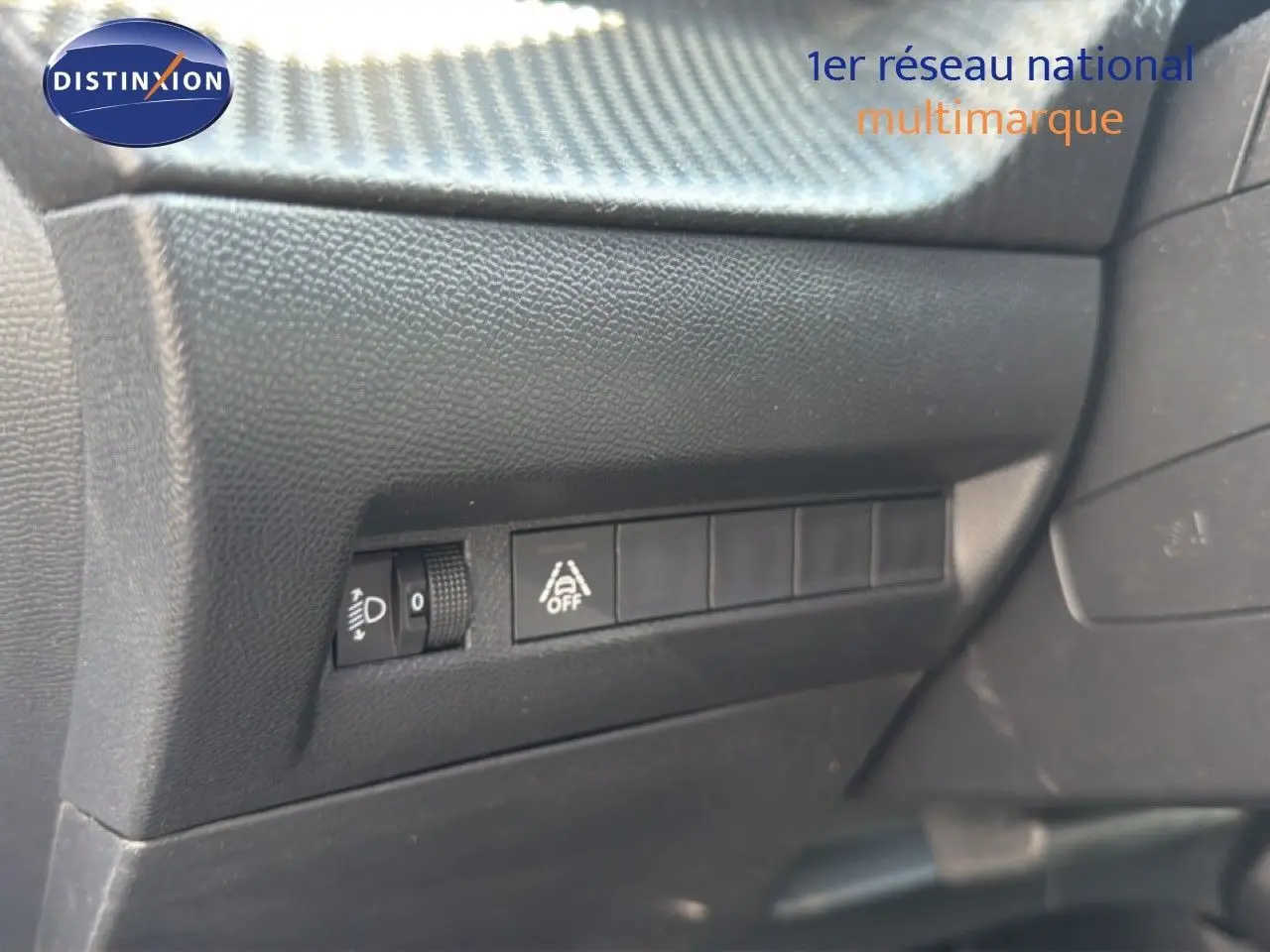 Vue rapprochée des commandes de réglage des phares et d'activation de l'alerte de franchissement de ligne dans un Peugeot 2008.