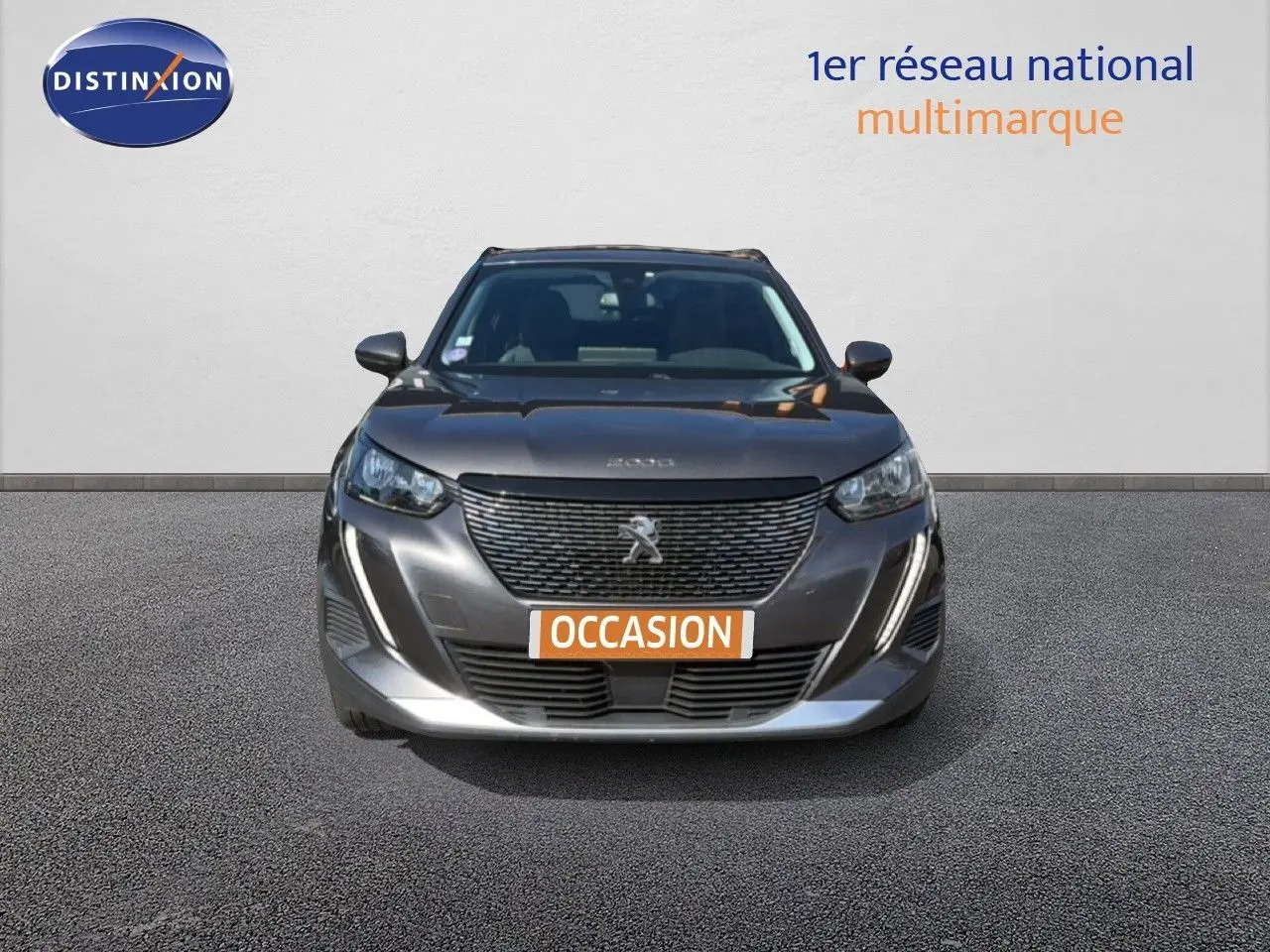 Vue frontale d'un Peugeot 2008 gris platinium avec calandre noire et plaque "OCCASION" orange.