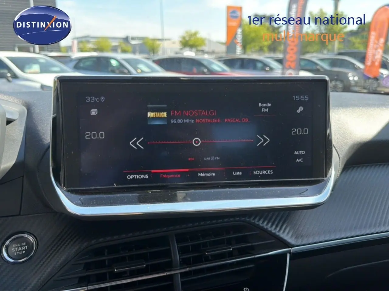 Vue rapprochée de l’écran tactile central du tableau de bord d’une Peugeot 2008 gris platinium, affichant la radio FM.