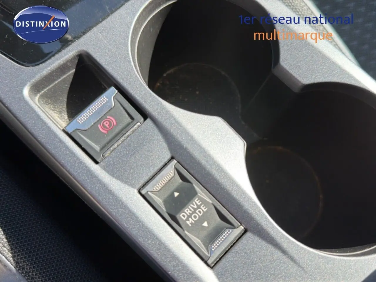 Vue rapprochée du bouton Drive Mode et frein à main électrique sur la console centrale du Peugeot 2008 gris platinium.