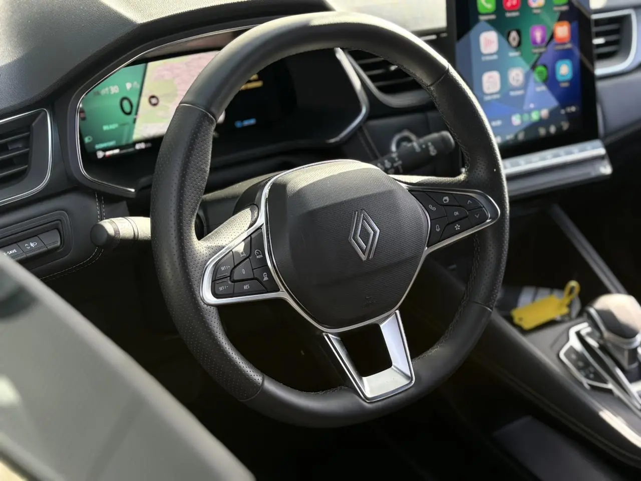 Vue rapprochée du volant noir perforé du Renault Symbioz 2025 avec tableau de bord numérique et écran tactile vertical.