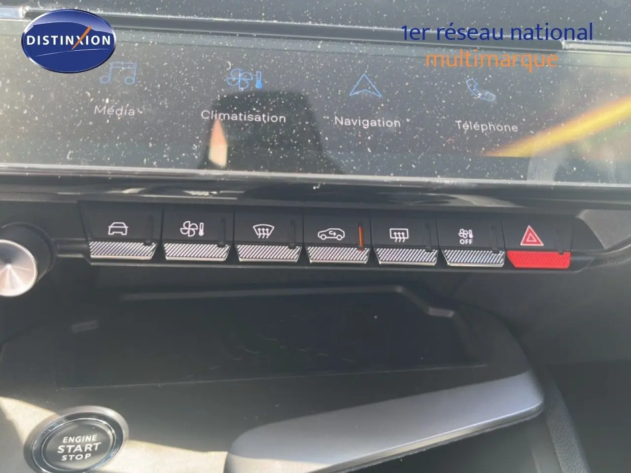 Vue rapprochée de la console centrale de la Peugeot 308 Hybrid 2025, avec boutons de climatisation et écran tactile.