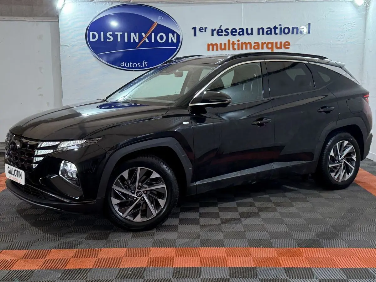 Hyundai Tucson noir en 3/4 avant droit, avec jantes alliage et calandre distinctive sous un panneau Distinxion.