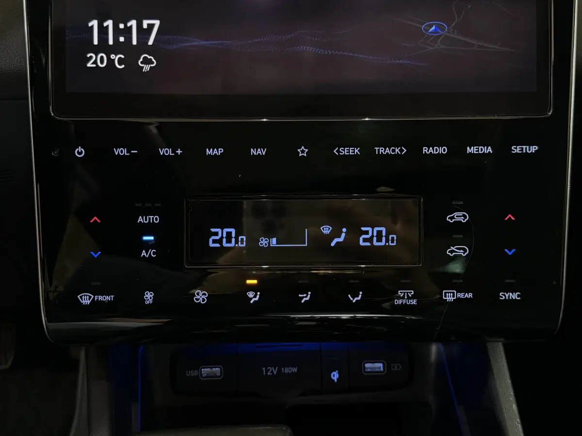 Gros plan sur la console centrale tactile du Hyundai Tucson noir 2021, affichant la climatisation digitale et commandes multimédia.