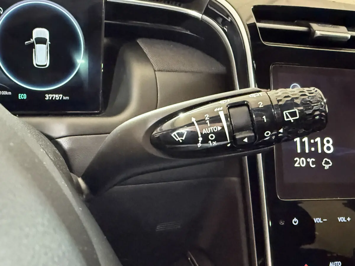 Gros plan sur la commande d'essuie-glace du tableau de bord noir du Hyundai Tucson 2021 hybride, affichage digital visible.