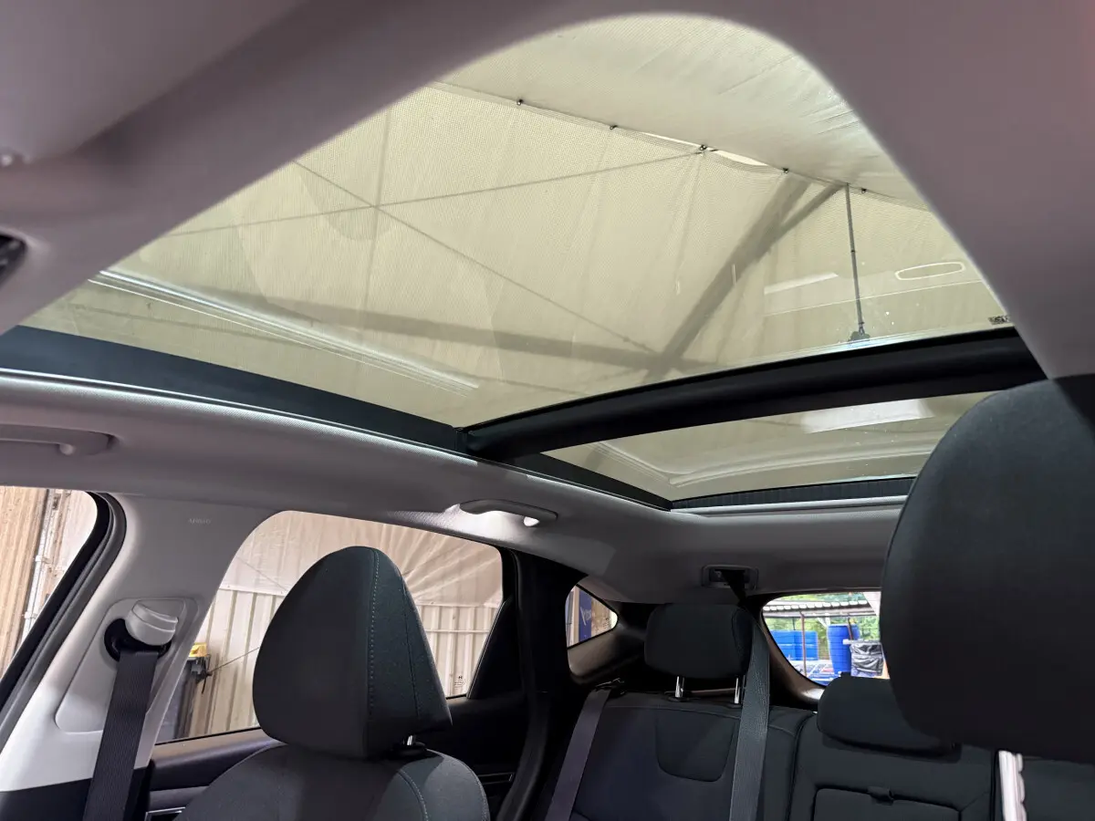 Vue intérieure arrière du Hyundai Tucson noir 2021 avec toit panoramique et sièges tissu gris foncé.