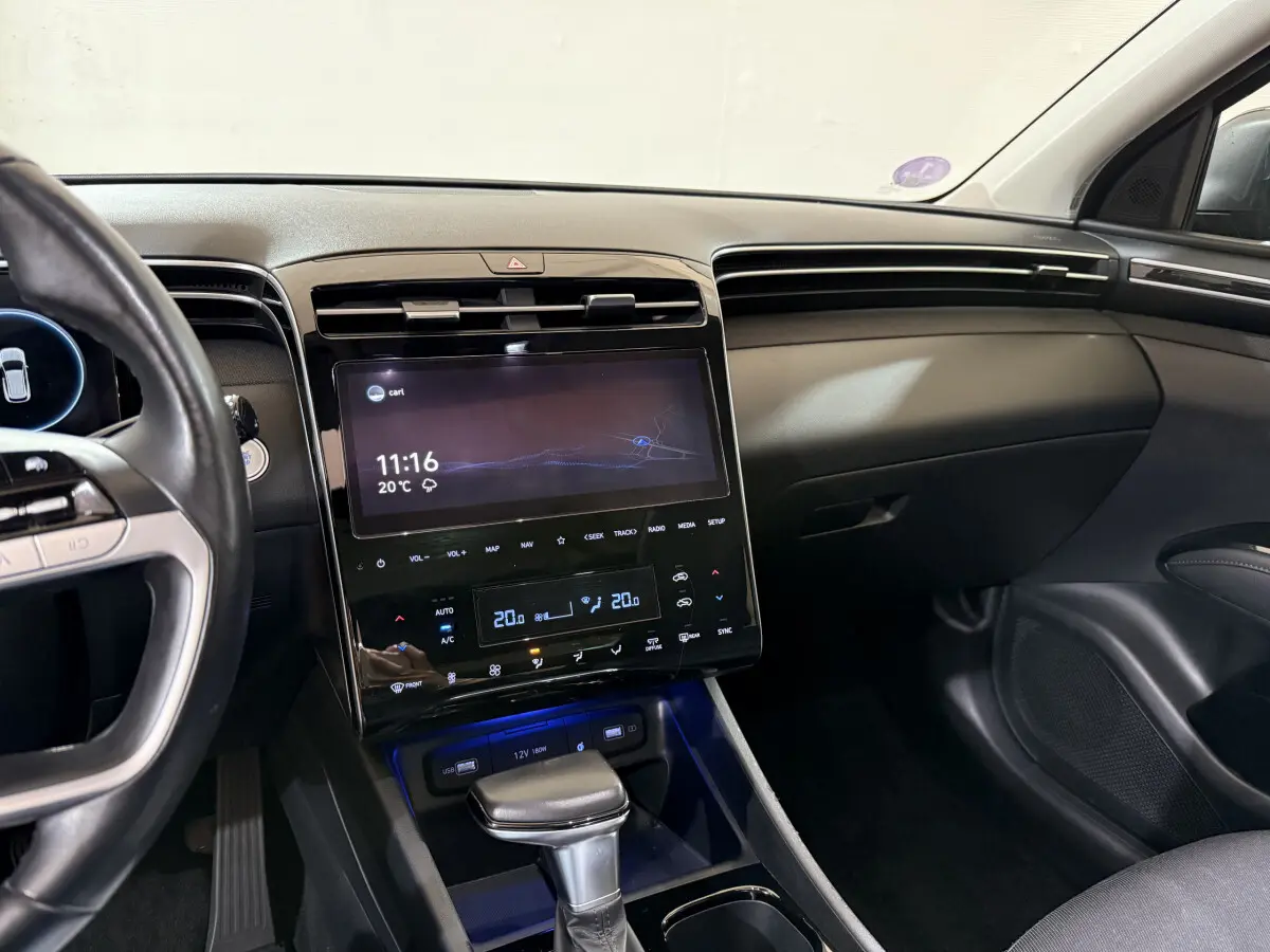 Vue intérieure du tableau de bord et console centrale du Hyundai Tucson noir, avec écran tactile et commandes digitales.