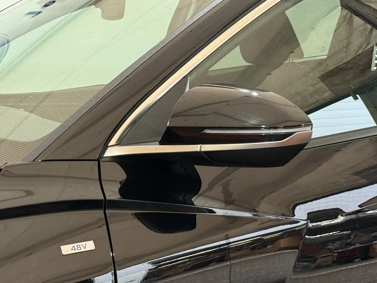 Gros plan sur le rétroviseur côté gauche noir brillant du Hyundai Tucson hybride 48V 2021 avec badge 48V visible.