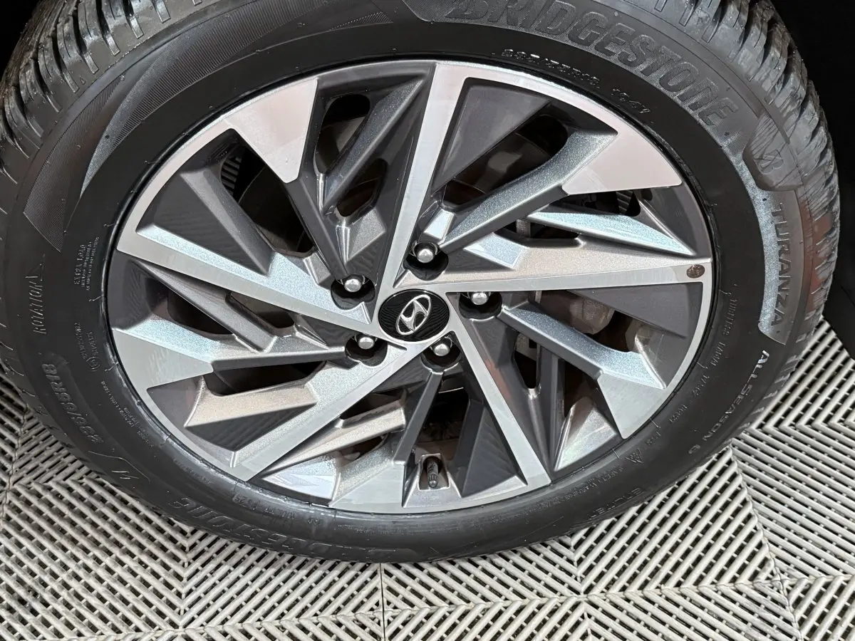 Gros plan sur la jante alliage argentée du Hyundai Tucson noir 2021, mettant en valeur le logo Hyundai central.