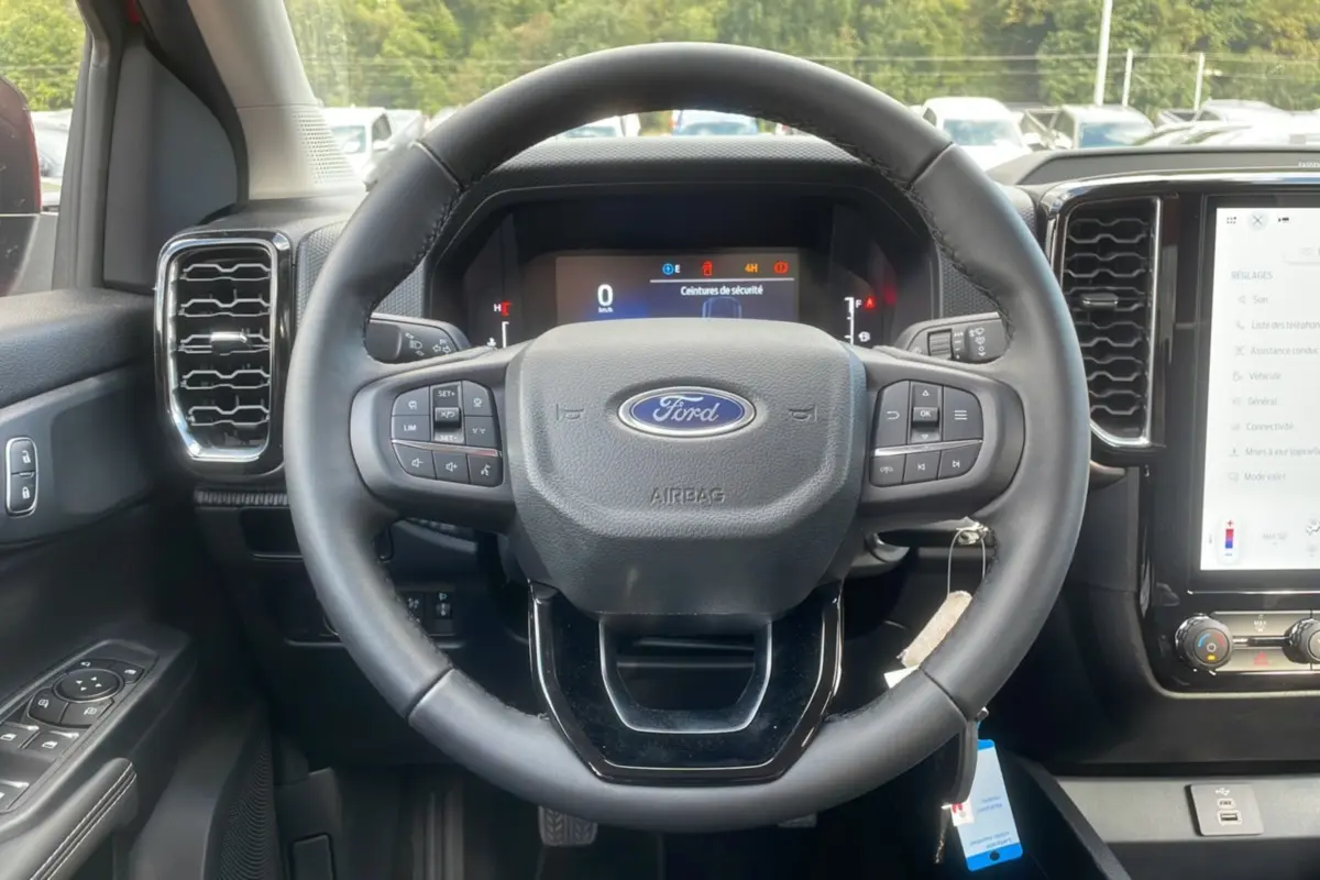Vue centrée sur le volant du Ford Ranger 2025 avec commandes intégrées et tableau de bord numérique.