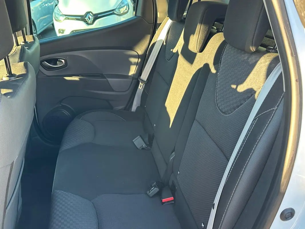 Vue intérieure côté droit montrant la banquette arrière noire de la Renault Clio IV blanche de 2016.