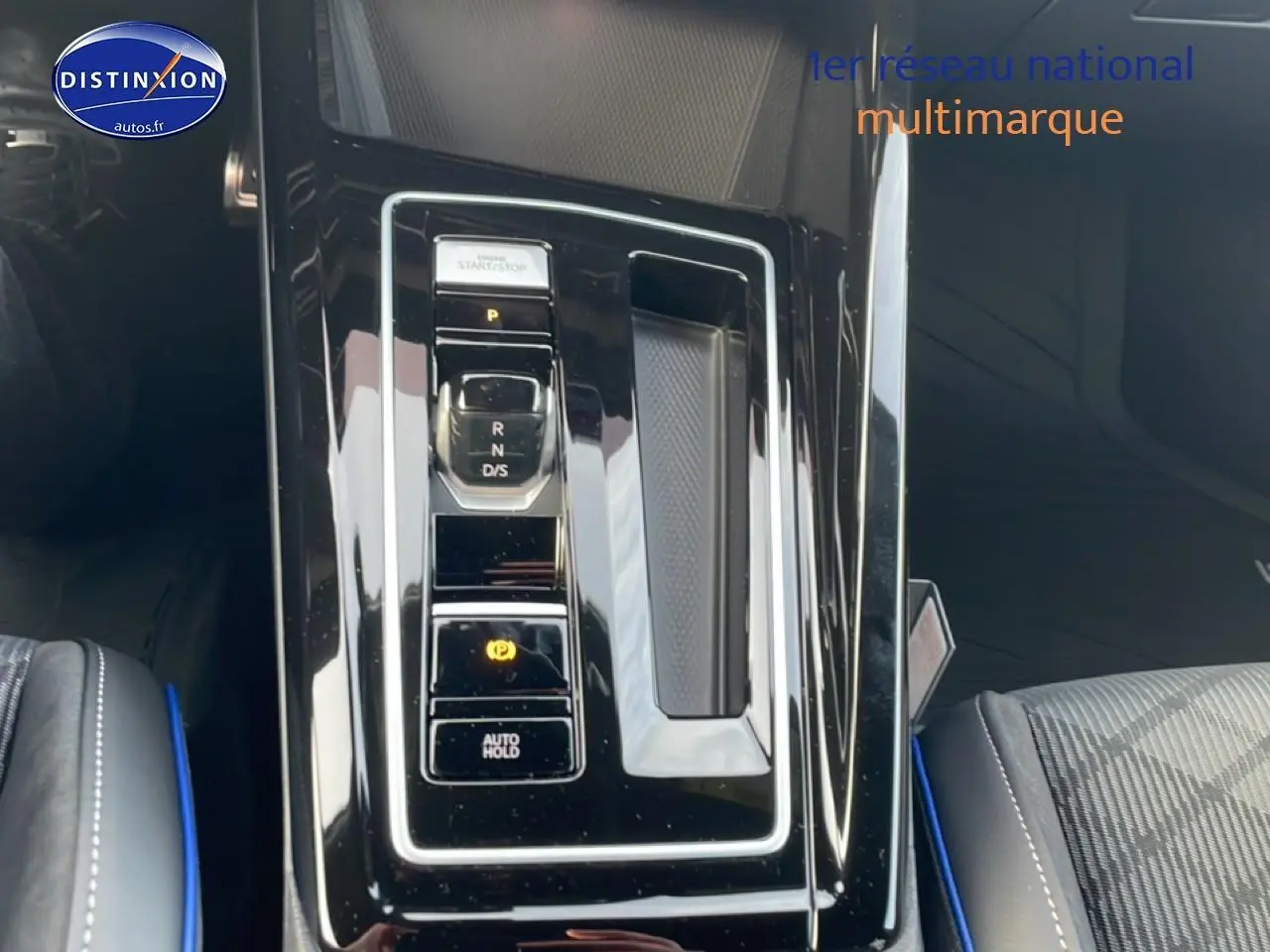 Vue rapprochée de la console centrale noire brillante avec levier de vitesses automatique sur Volkswagen Golf gris 2026.