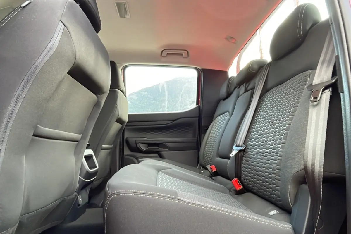 Vue intérieure arrière du Ford Ranger 2025, sièges noirs avec motifs texturés et ceintures de sécurité visibles.