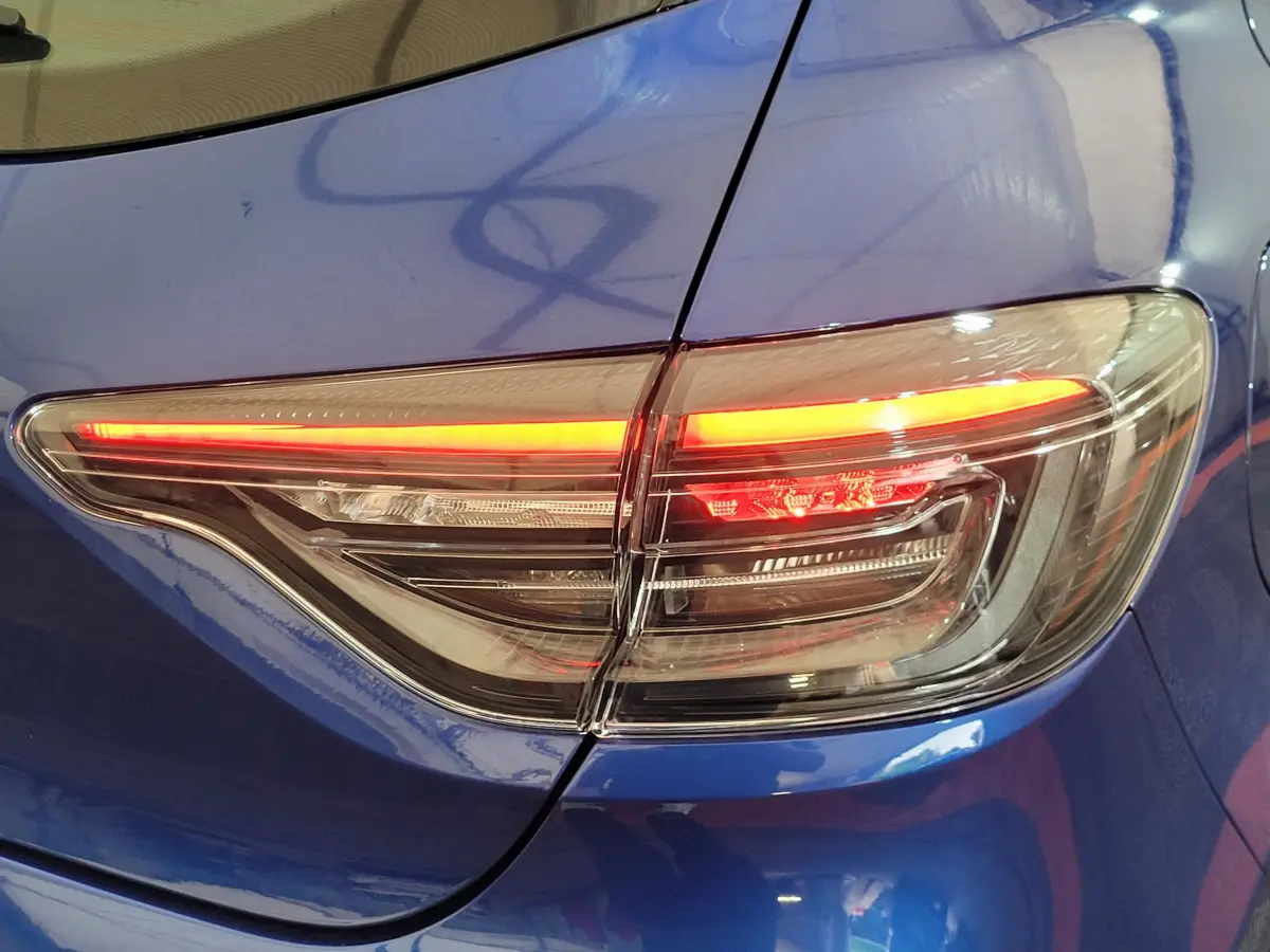 Feu arrière droit allumé sur Renault Clio bleu Evolution Blue dCi 100 de 2025, vue rapprochée du coffre et aile arrière.