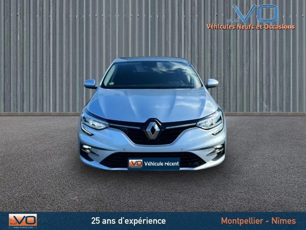 Vue frontale d'une Renault Mégane IV Berline gris clair 2022 avec phares LED et calandre noire brillante.