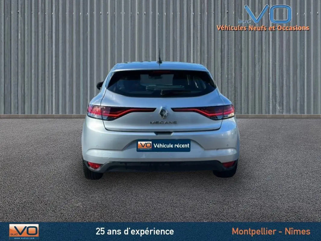 Vue arrière d'une Renault Mégane IV Berline gris clair de 2022, avec feux arrière LED et logo central visible.
